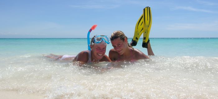 Girls on the beach with a snorkel mask and fins